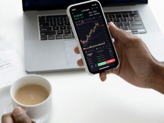 How to start investing in South Africa – person checking investment charts on phone and laptop