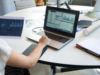 Data scientist analyzing dashboard charts and graphs on a laptop