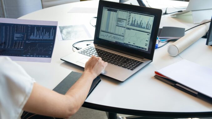 Data scientist analyzing dashboard charts and graphs on a laptop